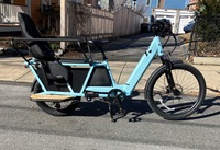 Image of Velotric Packer cargo bike with kid seat attached